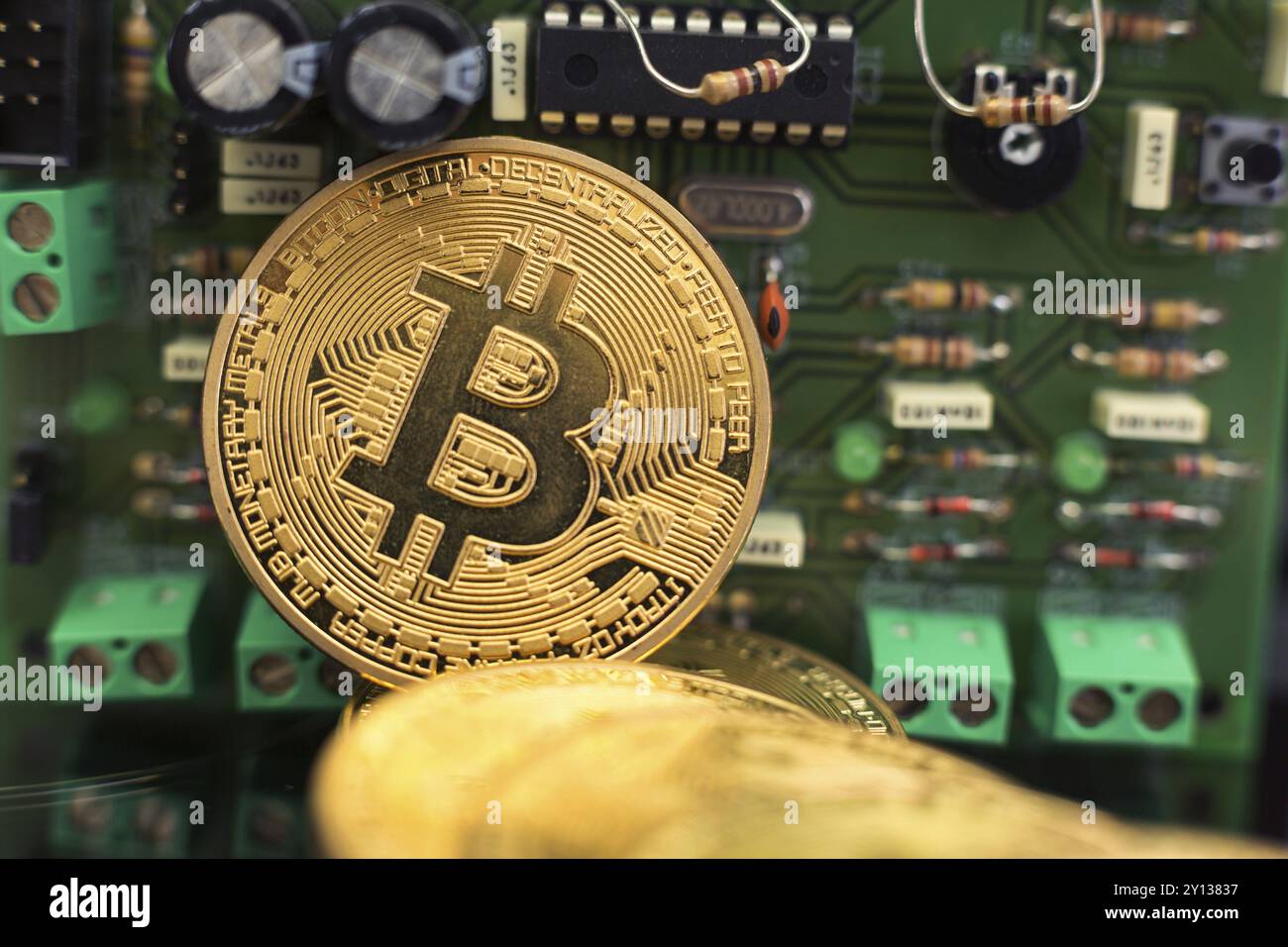 Moneta d'oro Bitcoin su microchip per circuiti stampati. Criptovaluta elettronica Foto Stock
