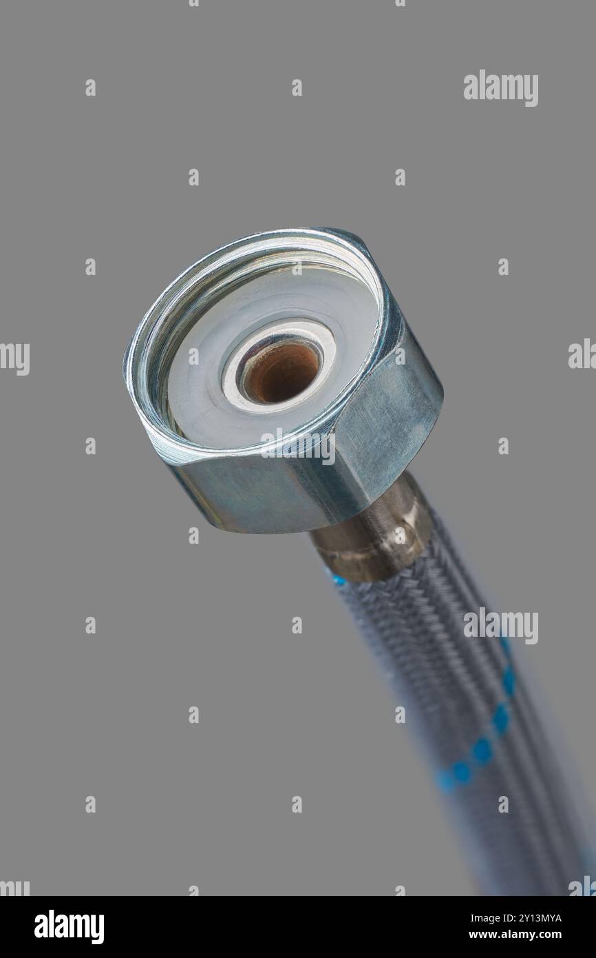 connettore estremità tubo dell'acqua intrecciato in acciaio inox sfondo grigio isolato per una vista ravvicinata, liner flessibile ad alta pressione con dispositivo di fissaggio filettato Foto Stock