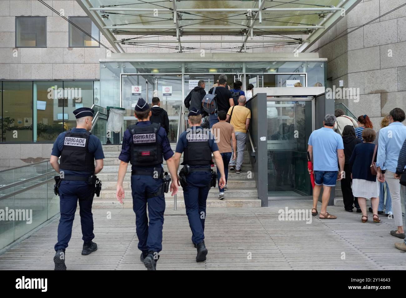 Police officers walk in the Avignon court house prior to the trial of Dominique Pelicot, in Avignon, southern France, Thursday, Sept. 5, 2024. A woman allegedly drugged by her ex-husband so that she could be raped by other men while she laid unconscious, is expected to testify before a panel of French judges. (AP Photo/Lewis Joly) Foto Stock