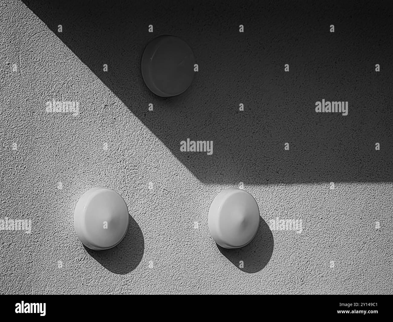 Tre lampadine rotonde: Luce e ombra sullo sfondo della parete. Foto Stock