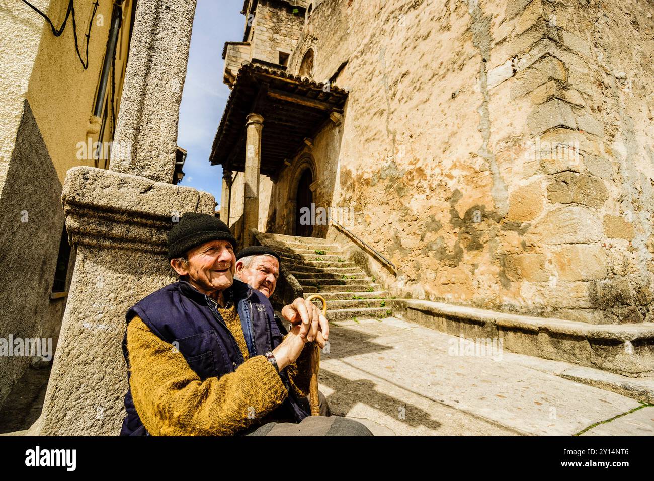 Gente del posto di fronte alla chiesa parrocchiale cattolica di San Lorenzo Mártir, XVI secolo, Garganta De la Olla, valle del Tiétar, la vera, Cáceres, Estremadura, Spagna. Foto Stock