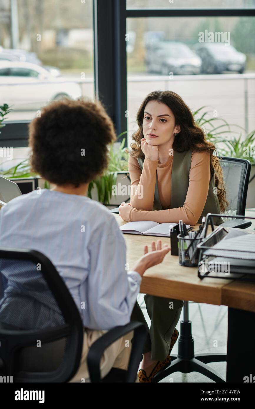 Due colleghi conversano con attenzione in una situazione di licenziamento impegnativa. Foto Stock