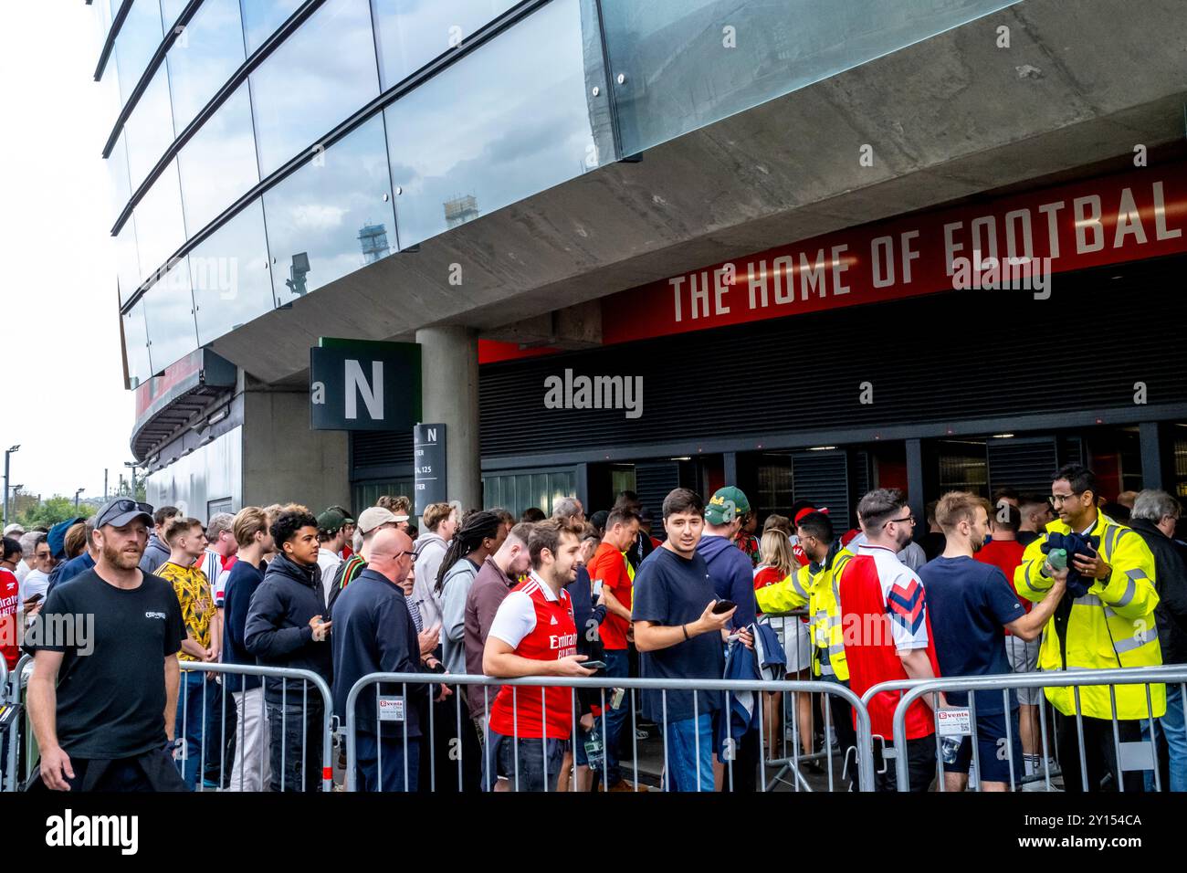 I tifosi dell'Arsenal Football fanno la fila per Un controllo di sicurezza prima di entrare all'Emirates Stadium, Londra, Regno Unito. Foto Stock