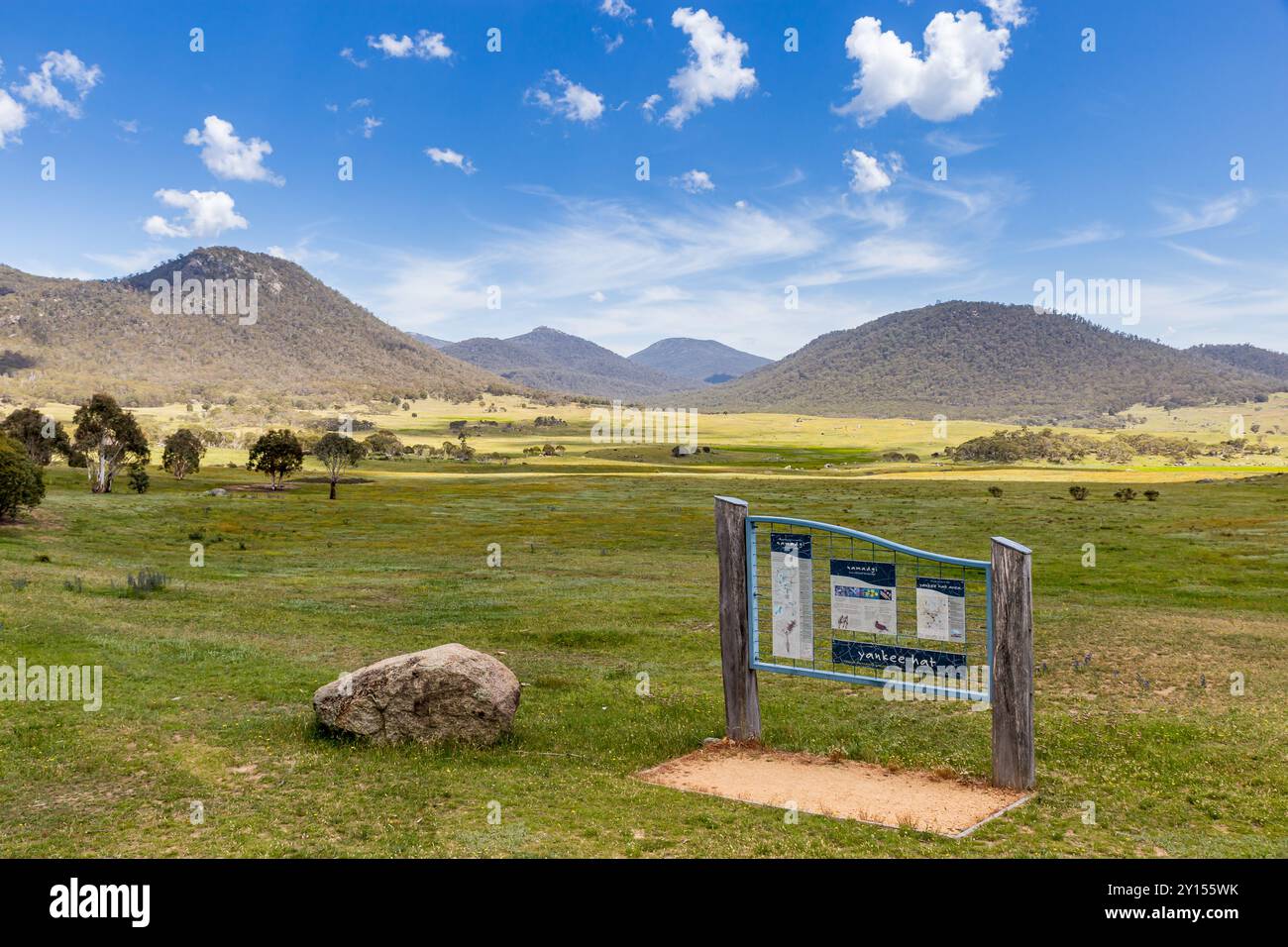 Un tranquillo paesaggio mostra il fiume Bogong con colline ondulate e un cielo limpido nel Parco Nazionale di Namadgi, invitando a esplorare e godersi la natura. Foto Stock