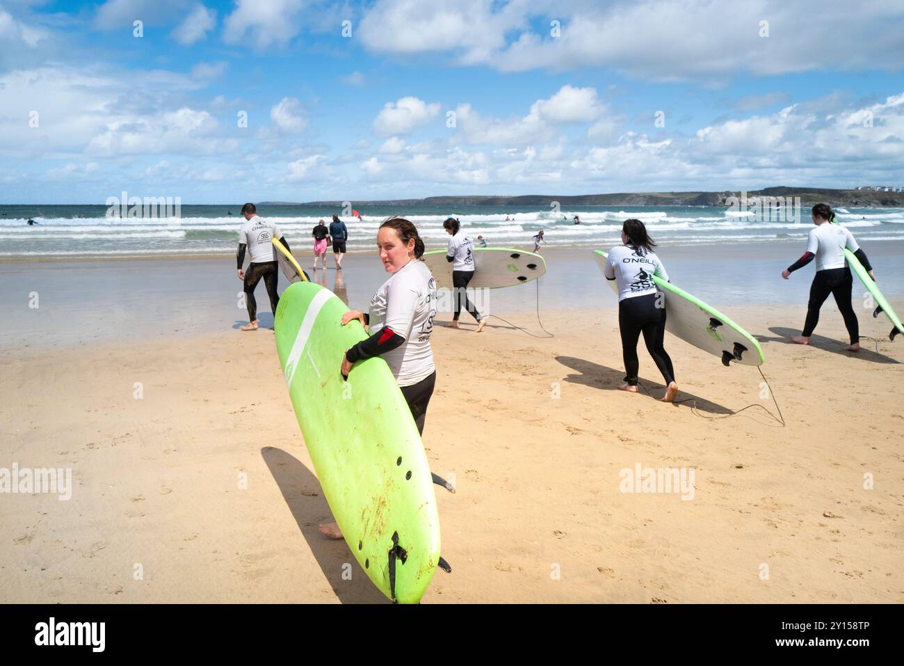 Un gruppo di principianti di surf che iniziano una lezione di surf con la scuola di surf SSS a Towan Beach a Newquay in Cornovaglia nel Regno Unito. Foto Stock