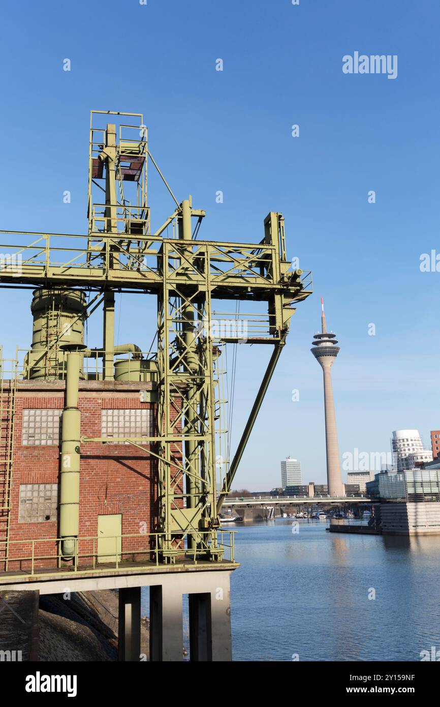 Germania, Dusseldorf, i vecchi moli e la moderna torre mediatica (Rheinturm) sul fiume Reno. Foto Stock