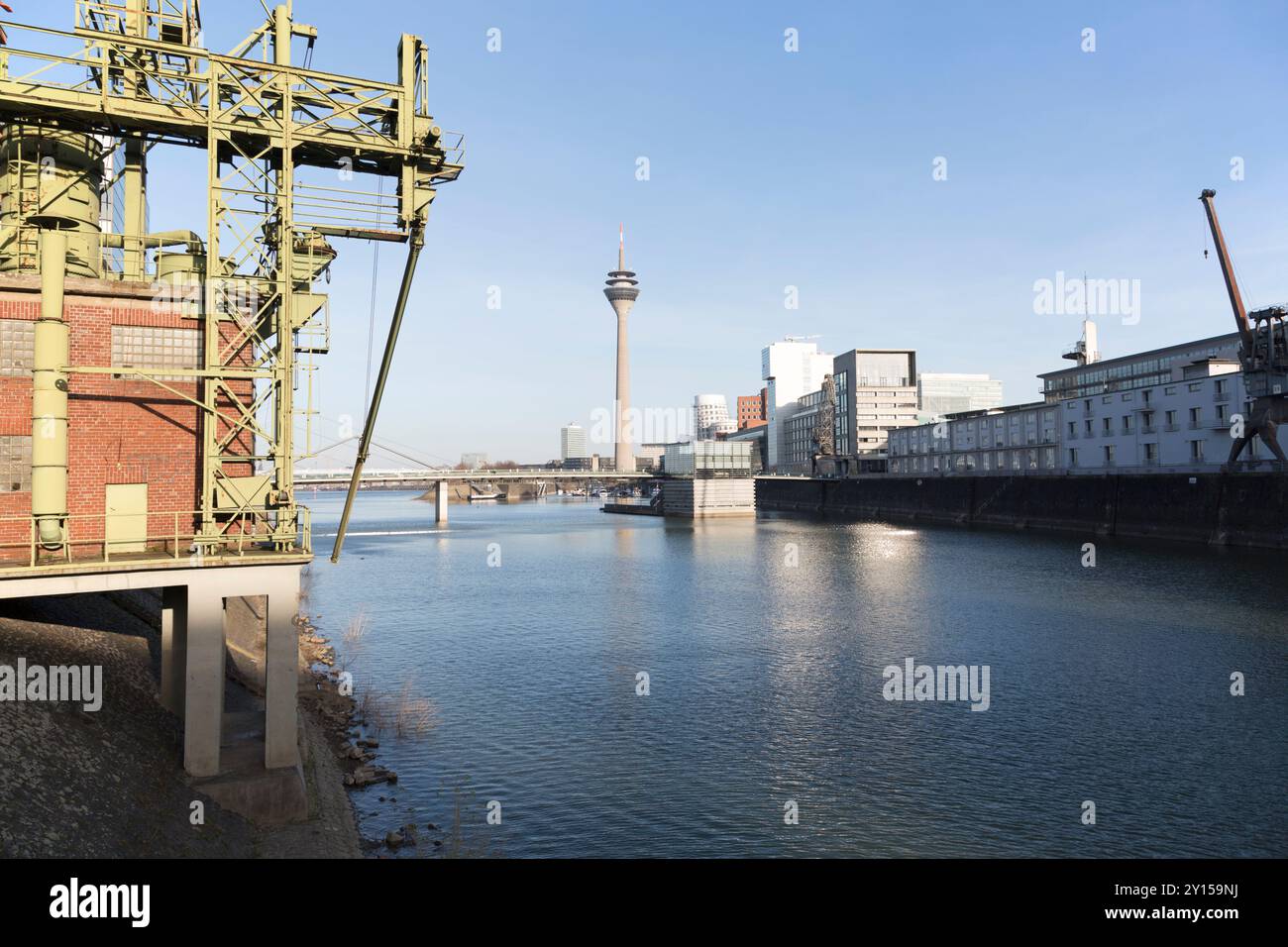 Germania, Dusseldorf, i vecchi moli e la moderna torre mediatica (Rheinturm) sul fiume Reno. Foto Stock