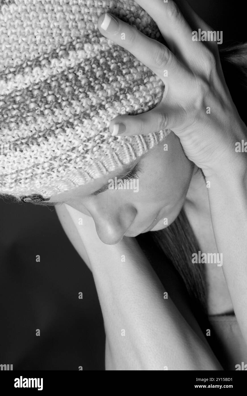 Donna caucasica di 20-25 anni che indossa un berretto da toboga, tiene la testa in pericolo, mostra segni di depressione, USA. Foto Stock