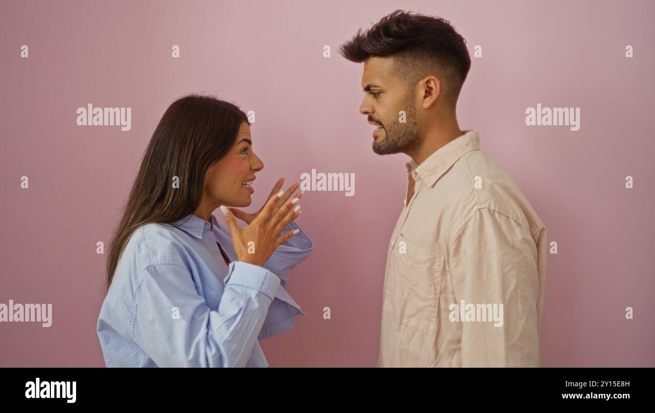 Donna e uomo discutono di problemi di relazione di fronte a uno sfondo rosa, mostrando emozioni e comunicazione tra una coppia. Foto Stock