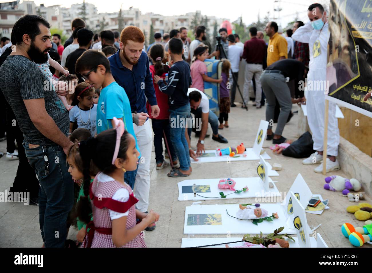 Agosto 2013. Una veglia si tiene a Idlib per commemorare il nono anniversario di un presunto attacco chimico da parte delle forze governative siriane a Ghouta orientale. I manifestanti hanno tenuto striscioni che ritenevano il governo di Bashar al-Assad responsabile dell'attacco e chiedevano giustizia a nome delle vittime. Si ritiene che più di 1.400 civili siano morti in un attacco con armi chimiche nella parte orientale di Ghouta e nelle aree di Muadamiyat al-Sham di Damasco il 21 agosto 2013. Un certo numero di militanti armati del gruppo di opposizione Hay'at Tahrir al-Sham hanno partecipato alla veglia Foto Stock