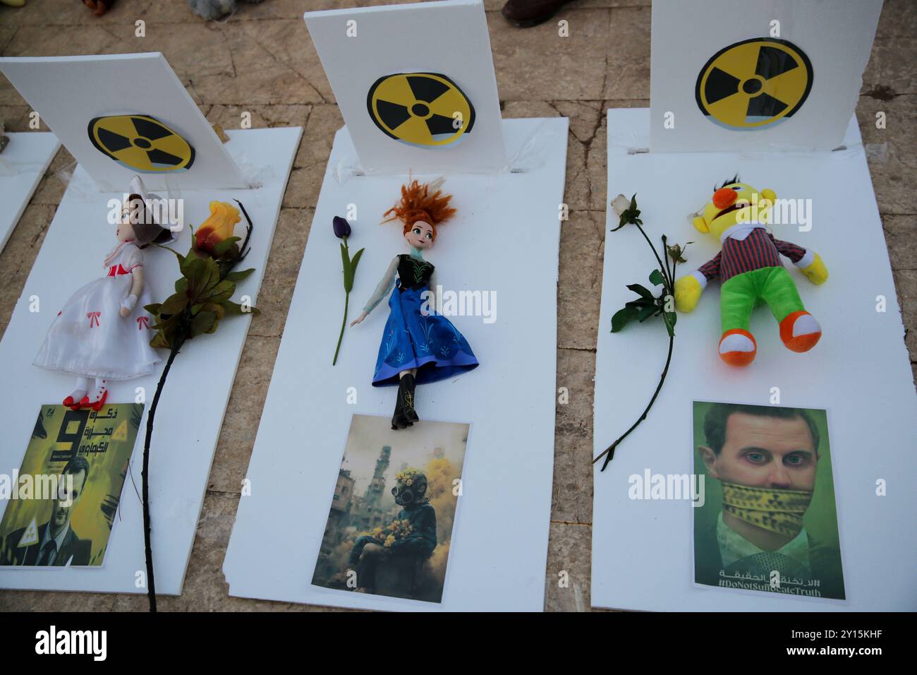 Agosto 2013. Una veglia si tiene a Idlib per commemorare il nono anniversario di un presunto attacco chimico da parte delle forze governative siriane a Ghouta orientale. I manifestanti hanno tenuto striscioni che ritenevano il governo di Bashar al-Assad responsabile dell'attacco e chiedevano giustizia a nome delle vittime. Si ritiene che più di 1.400 civili siano morti in un attacco con armi chimiche nella parte orientale di Ghouta e nelle aree di Muadamiyat al-Sham di Damasco il 21 agosto 2013. Un certo numero di militanti armati del gruppo di opposizione Hay'at Tahrir al-Sham hanno partecipato alla veglia Foto Stock