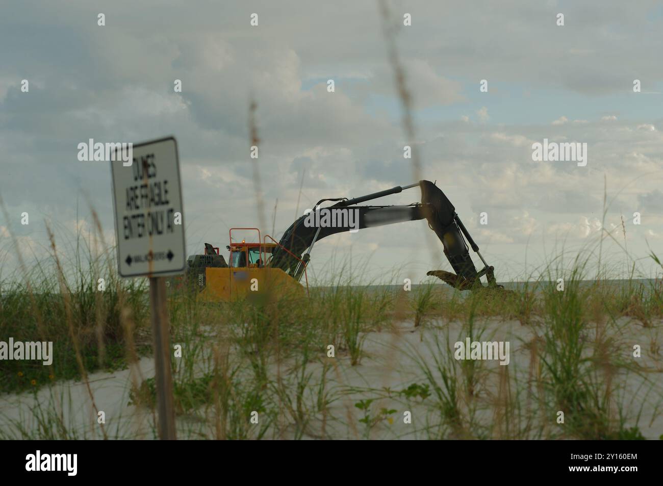 St. Pete Beach, Florida, verso il Golfo del Messico come macchine pesanti lavorano sul nutrimento delle spiagge . Vista su sabbia e avena marina. In un giorno nuvoloso in ritardo nel dopo Foto Stock