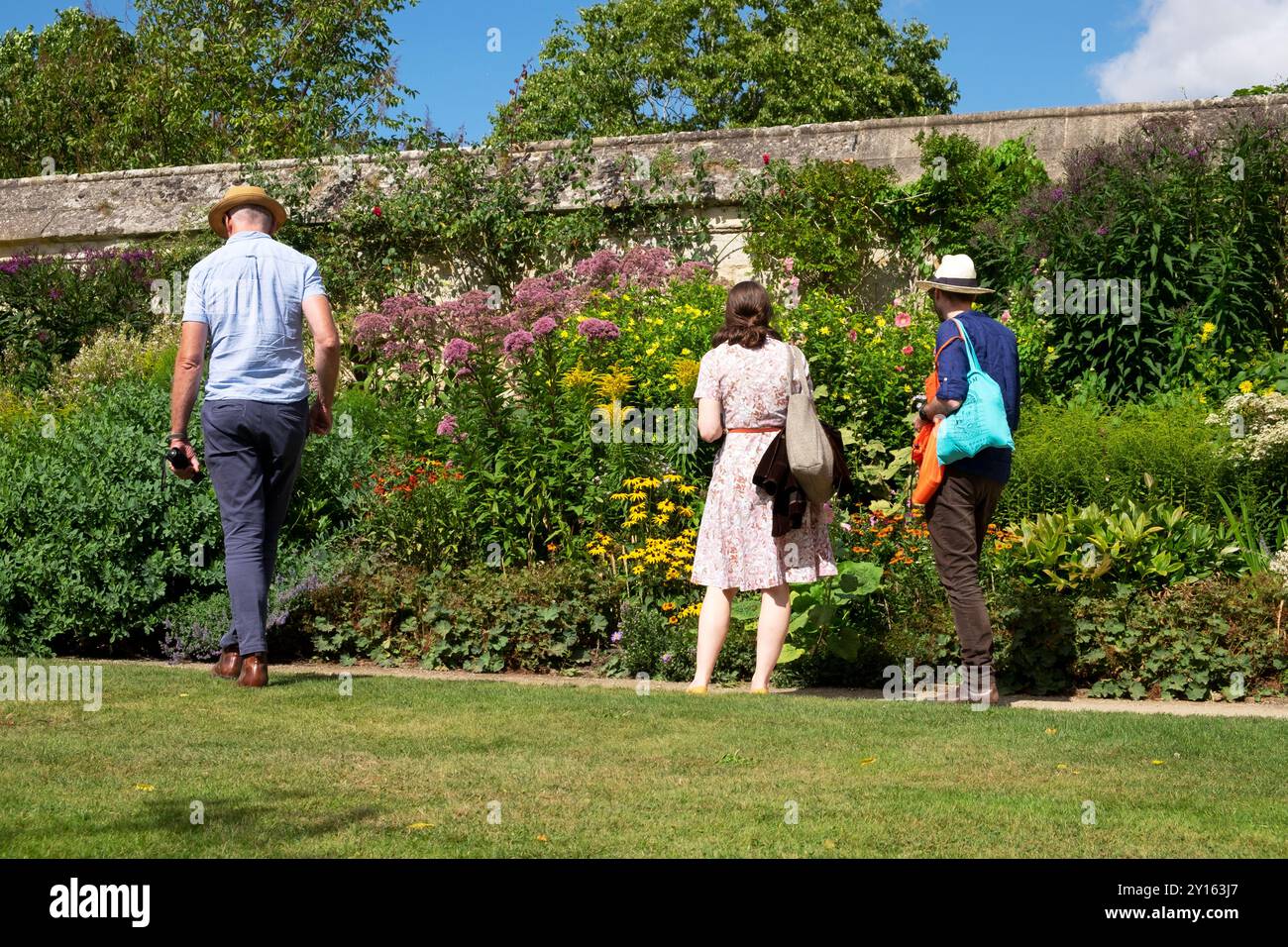 Persone che guardano un letto di fiori di confine erbacee a fine estate a Oxford Botanic Garden Oxfordshire Inghilterra Regno Unito Gran Bretagna agosto 2024 KATHY DEWITT Foto Stock