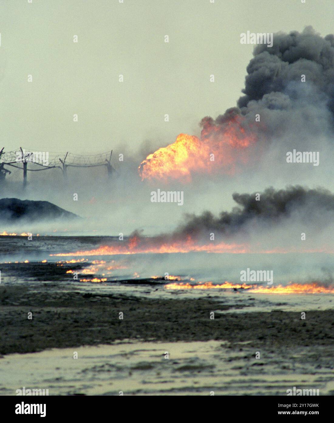 Prima guerra del Golfo: 7 marzo 1991 il petrolio greggio brucia e inquina il deserto e un pozzo di petrolio sabotato brucia fiamme e fumo nel giacimento petrolifero di Burgan, a sud di Kuwait City. Foto Stock