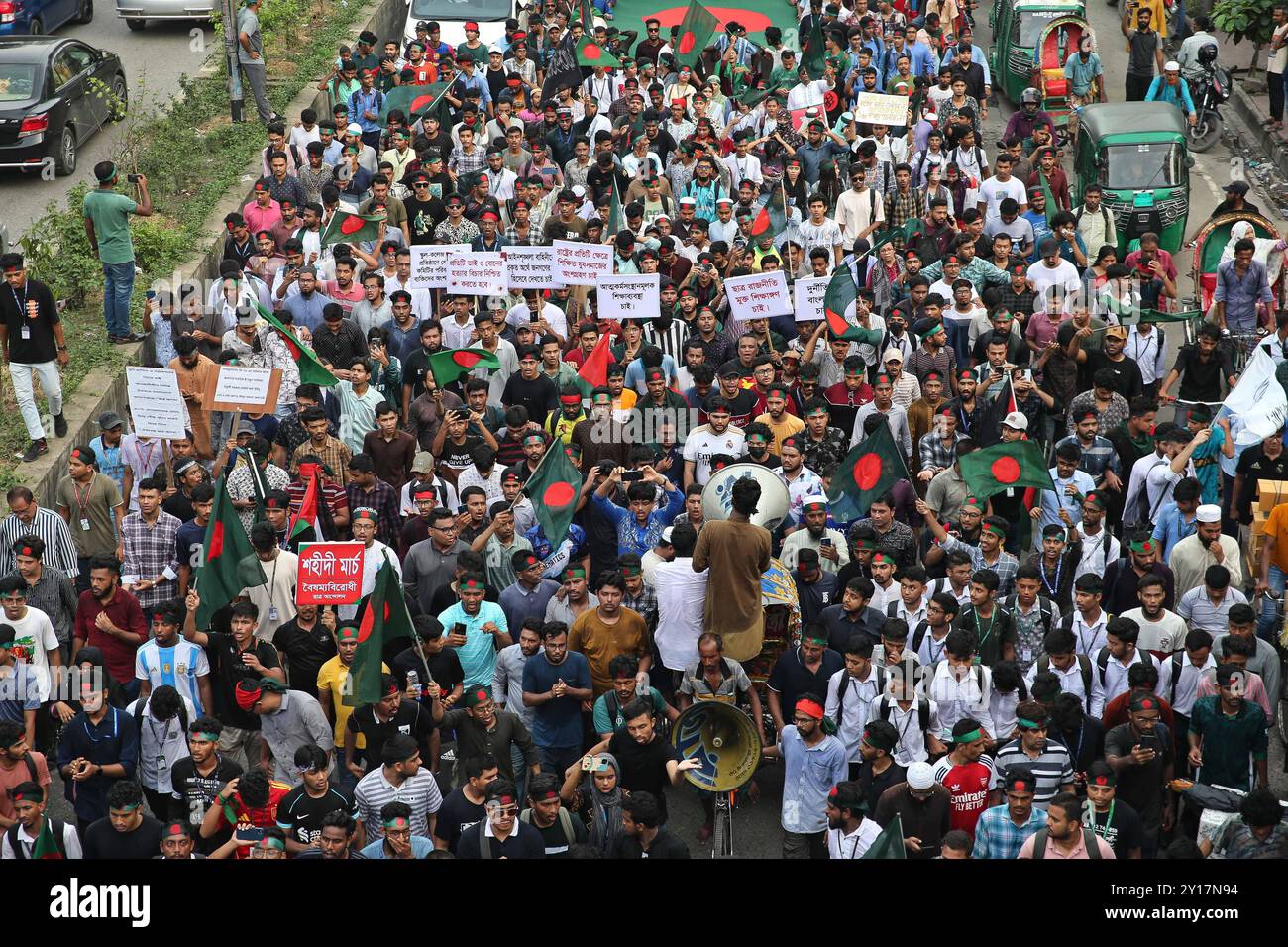 Marcia Shahidi a Dacca i manifestanti ondeggiano la bandiera nazionale del Bangladesh durante la marcia martiriana, una manifestazione organizzata dagli studenti contro la discriminazione per celebrare un mese per l'estromissione dell'ex primo ministro Sheikh Hasina, a Dacca il 5 settembre 2024. Il Premier deposto del Bangladesh Sheikh Hasina dovrebbe tacere mentre era in esilio in India fino a quando non viene portata a casa per il processo, il leader ad interim Muhammad Yunus ha detto ai media indiani il 5 settembre. Hasina, 76 anni, fuggì in India in elicottero un mese fa mentre i manifestanti marciavano sul suo palazzo in una drammatica fine al suo dominio pugno di ferro di 15 anni. Dhaka Dhaka Foto Stock