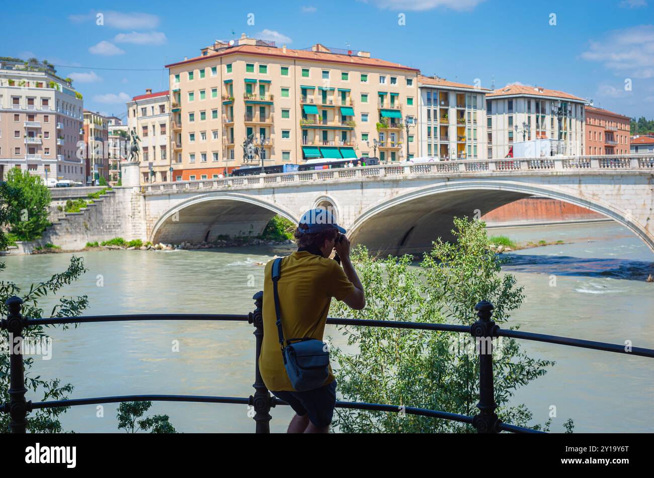 Il turista sta sta fotografando il famoso ponte della Vittoria sul fiume Adige nella storica città di Verona, in Italia. Foto Stock