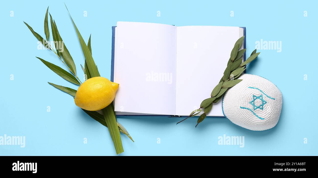 Quattro specie (lulav, hadas, arava, etrog) come simboli festivi Sukkot, kippah e libro aperto su sfondo blu Foto Stock