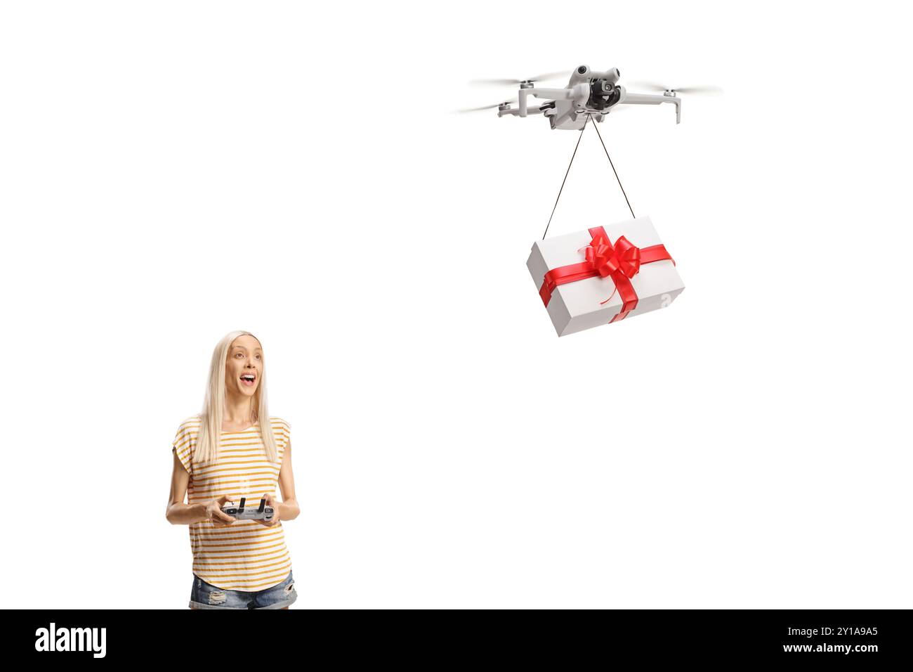 Giovane donna che vola su un drone con una scatola regalo isolata su sfondo bianco Foto Stock