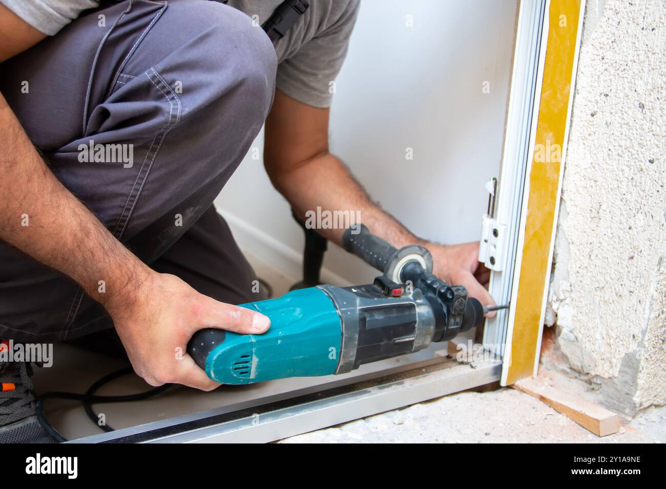 Falegnami professionisti che installano una porta d'ingresso in un nuovo appartamento. L'addetto all'installazione delle portiere ha sostituito il vecchio con uno nuovo Foto Stock