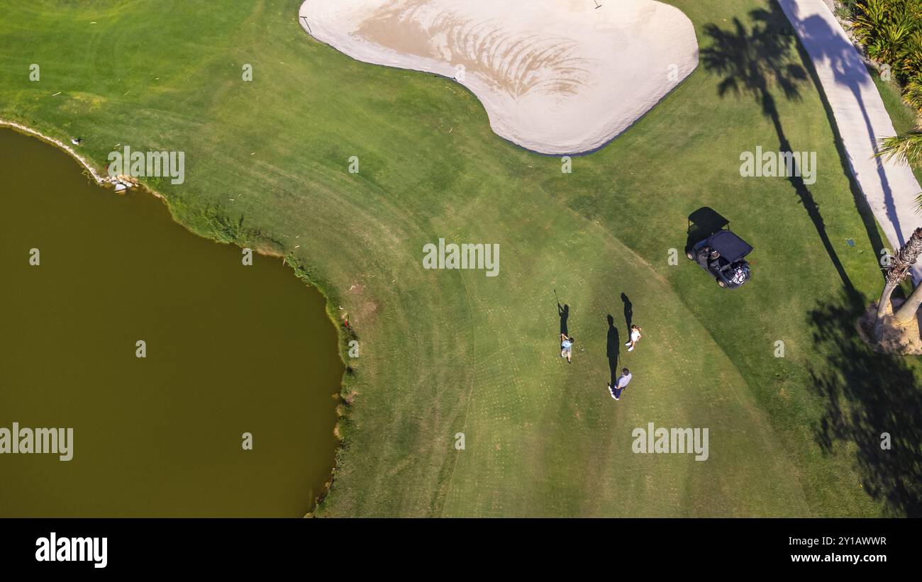 Vista aerea del lago in un campo da golf e delle persone che ci giocano Foto Stock