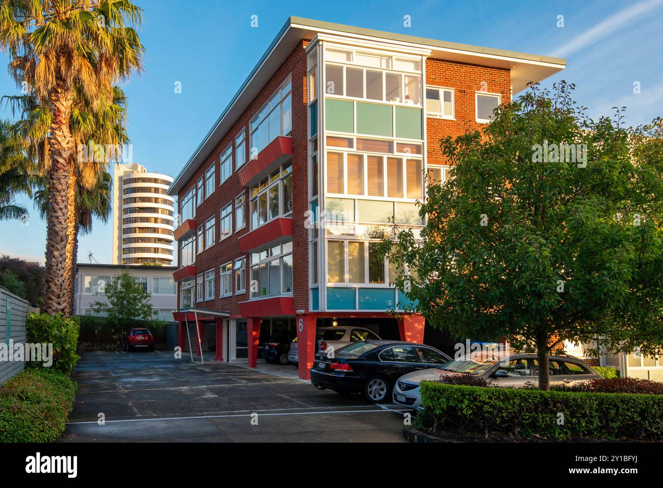 Appartamenti o appartamenti moderni della metà del secolo a Ponsonby, Auckland, nuova Zelanda, in contrasto con il moderno edificio a torre dietro di loro Foto Stock