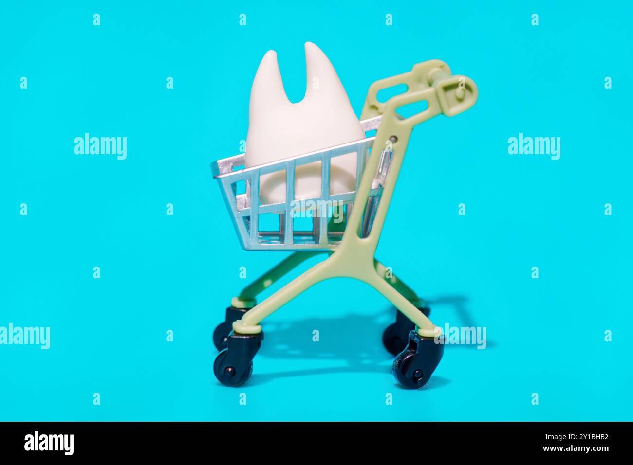 Piccolo modello dentale collocato in un carrello su uno sfondo colorato, che rappresenta i prodotti per la salute dentale. Foto Stock