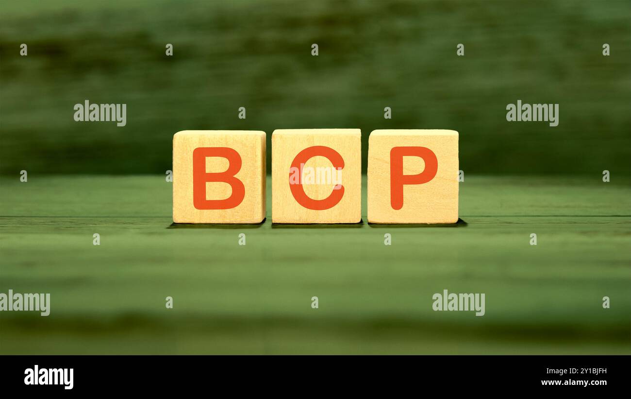 Piano di continuità aziendale BCP. BCP assemblato da cubi di legno su sfondo verde Foto Stock