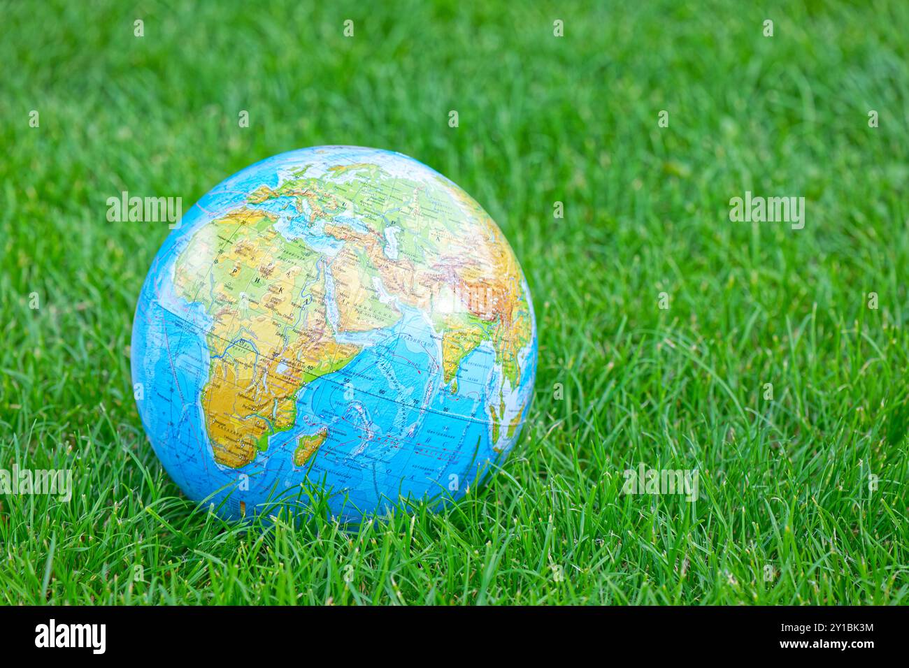 Globo terrestre su prato verde estivo Foto Stock