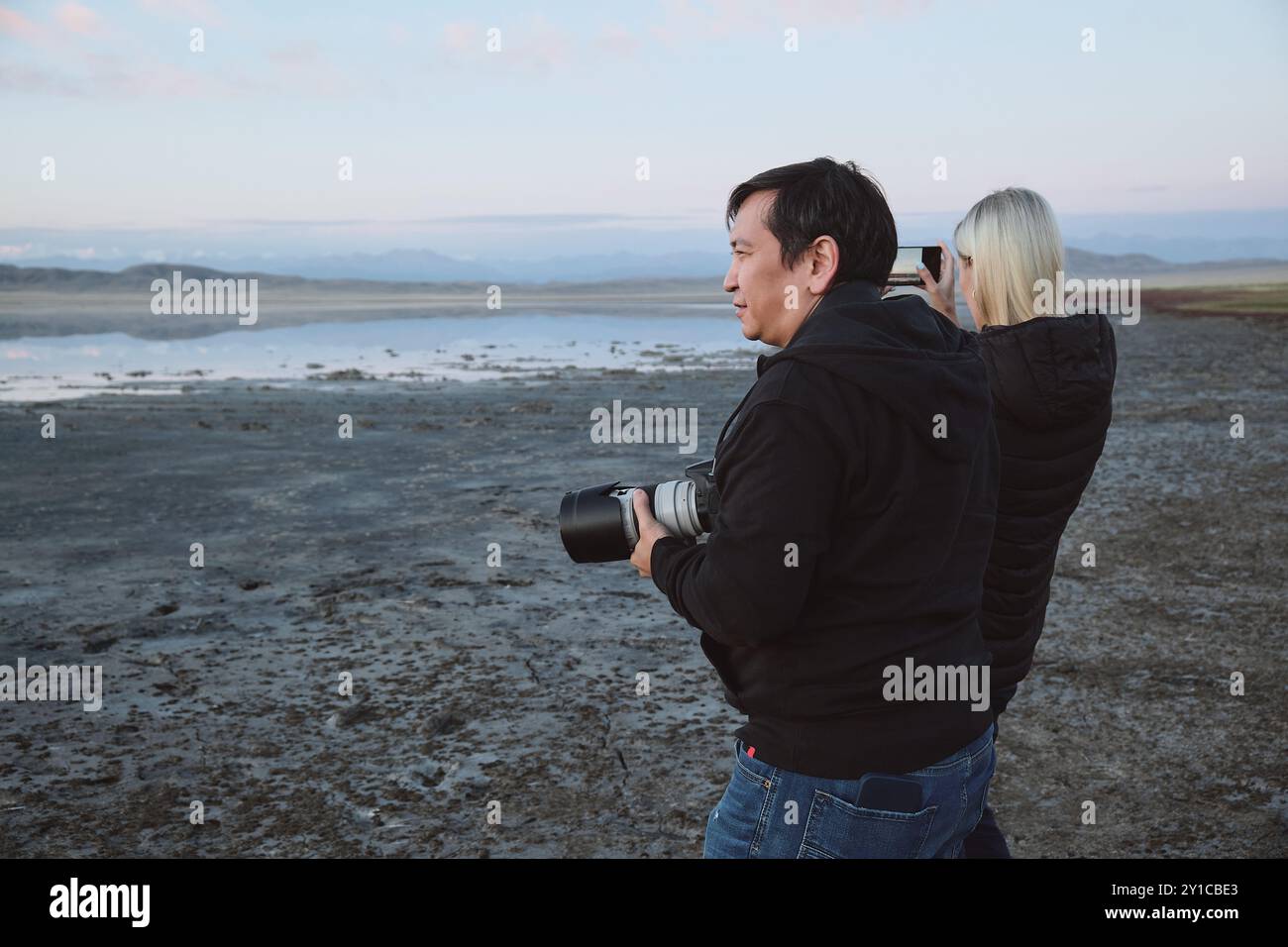 Fotografi che scattano foto da un lago panoramico a Dusk. Foto Stock