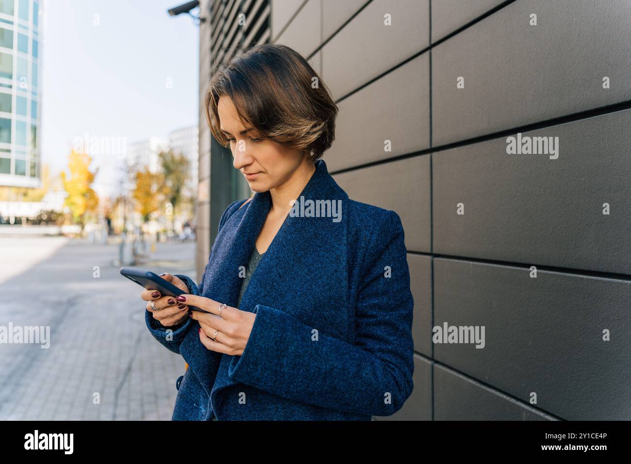 giovane donna che usa lo smartphone in un ambiente urbano Foto Stock