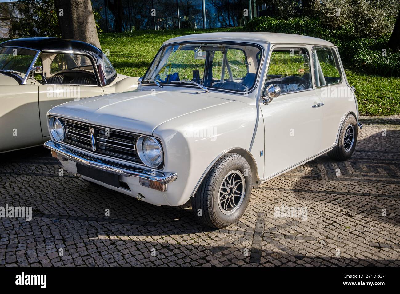 Lisbona, Portogallo - 20 gennaio 2024: Iconica auto bianca Leyland Mini Clubman parcheggiata su una strada acciottolata vicino al parco verde. berlina a 2 porte Foto Stock