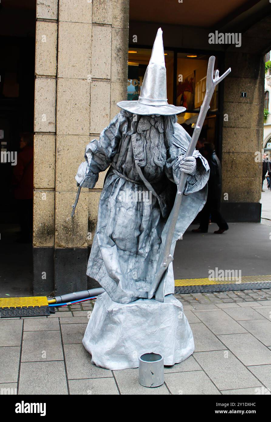 Germania, Düsseldorf - 21 dicembre 2013 - Un artista di strada vestito da mago, ricoperto di vernice argento, si erge su un marciapiede. L'esecutore ha un Foto Stock