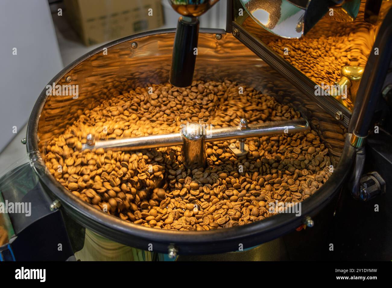 I chicchi di caffè vengono tostati nella tostatrice. Macinatura e tostatura del caffè Foto Stock