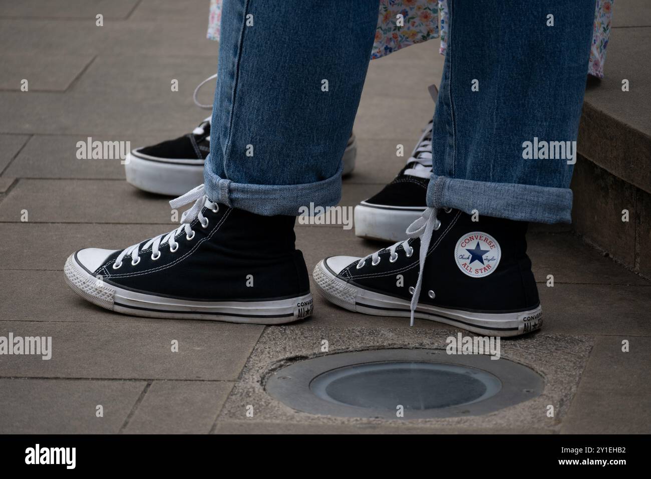 Persona che indossa jeans e scarpe Converse Foto Stock