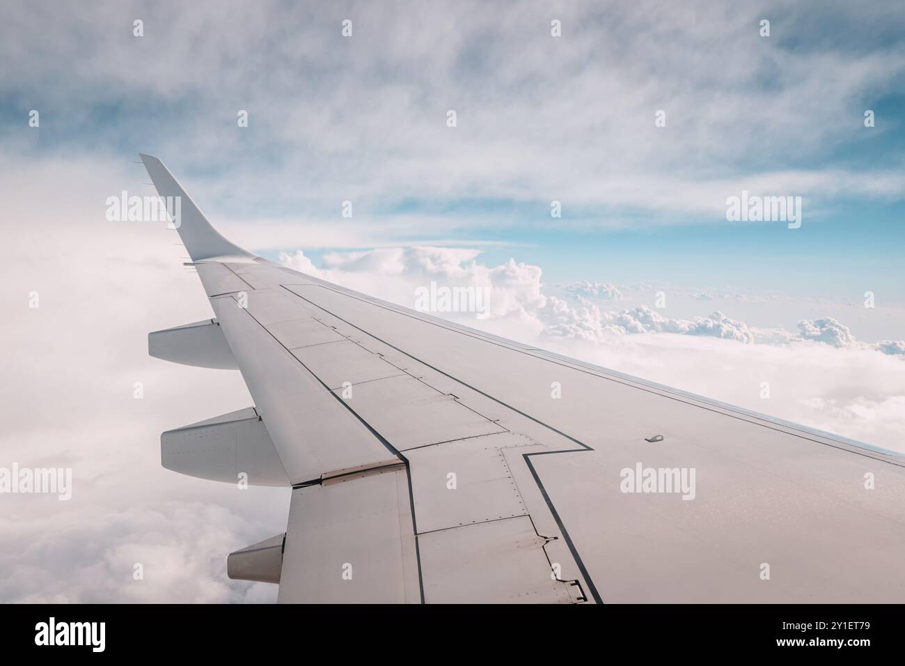 L'ala di un aereo di linea attraversa l'atmosfera, catturando la bellezza della natura e del tempo in una giornata di viaggio perfetta Foto Stock