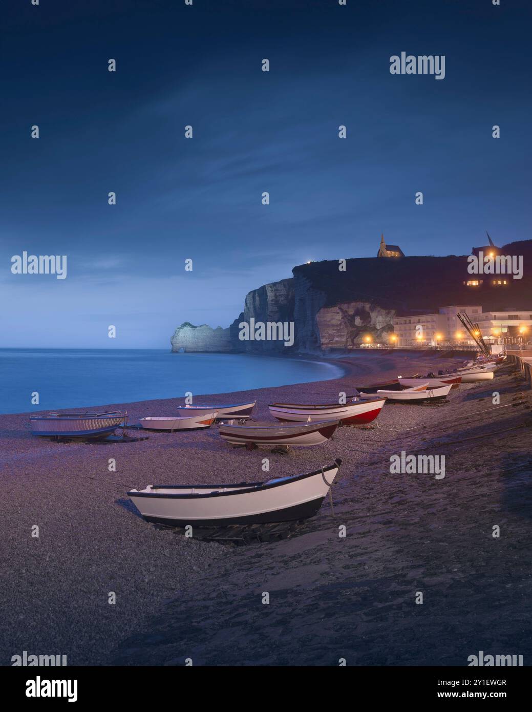 Ora blu sulle barche e sulla spiaggia di Etretat in una serata nebbiosa. Vista panoramica. Regione della Normandia, Francia, Europa. Foto Stock