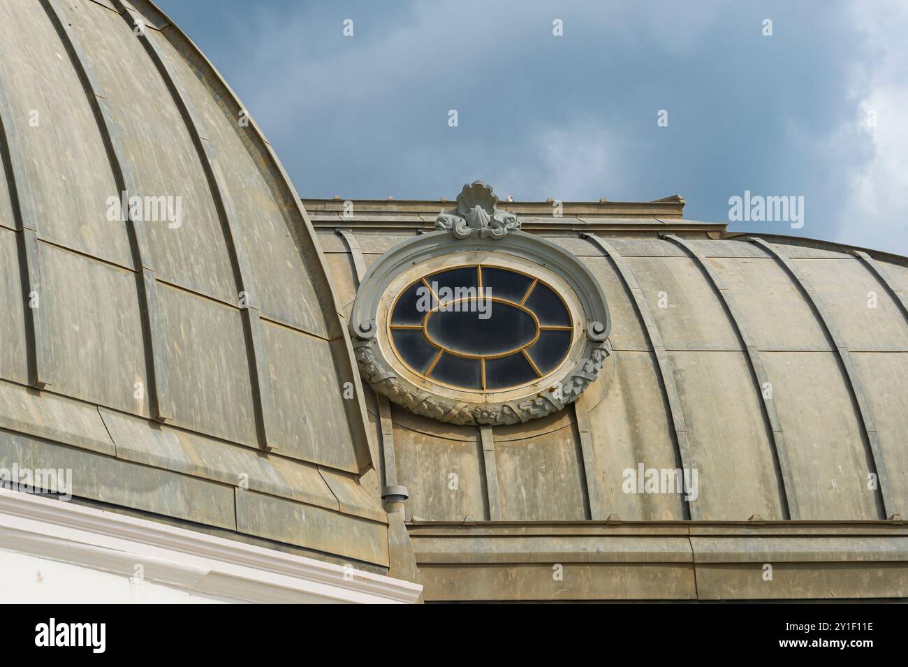 Primo piano di una finestra ornata sul tetto di un vecchio edificio con tetto in zinco. Foto Stock