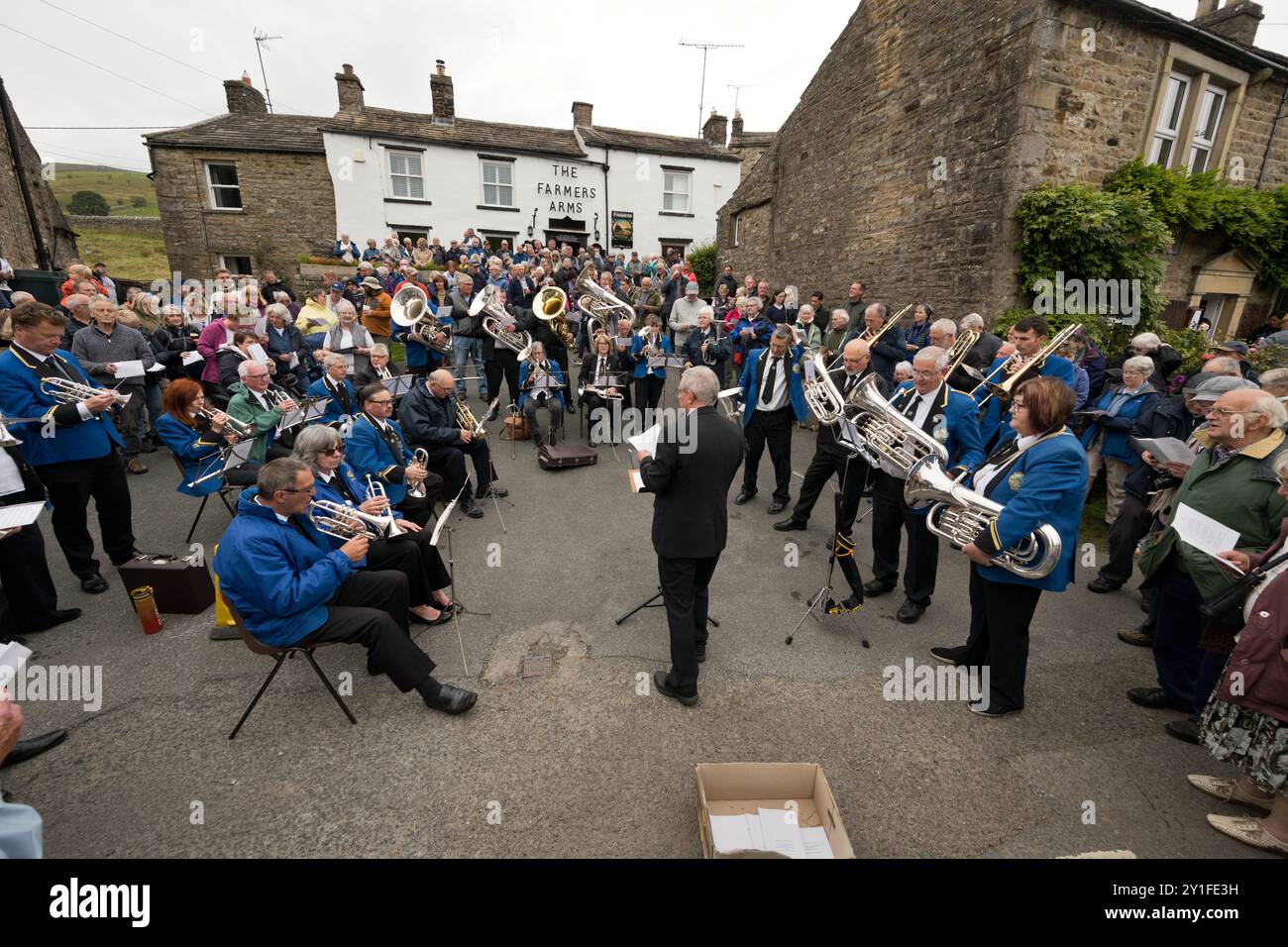 La Muker Silver Band guidò la comunità cantando fuori dal pub Farmers Arm dopo l'annuale Muker Show, Swaledale, North Yorkshire, settembre 2024 Foto Stock