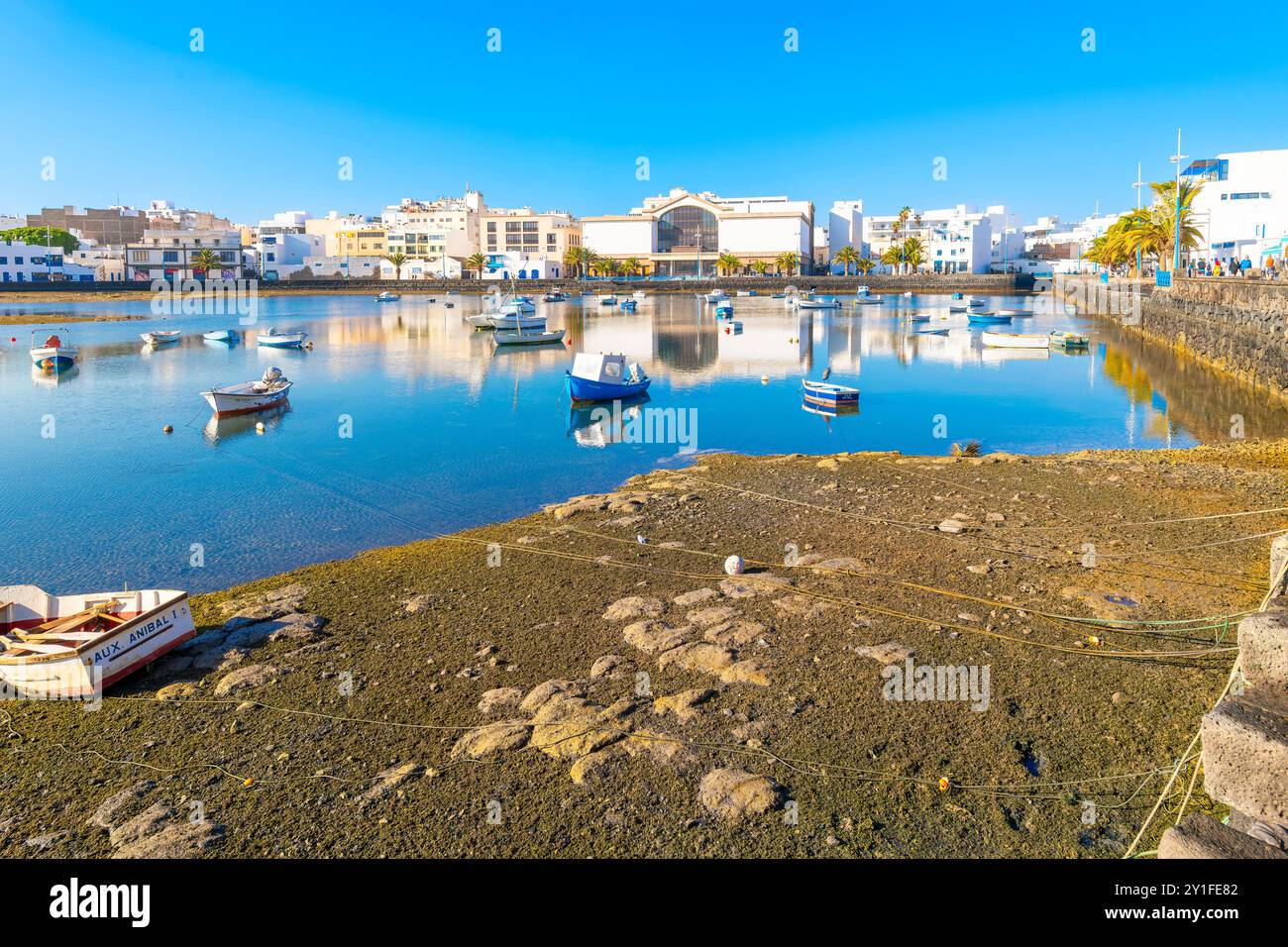 Piccole e colorate barche da pesca galleggiano nella laguna di acqua marina di Charco de San Gines presso la città spagnola di Arrecife, Spagna, Isole Canarie. Foto Stock