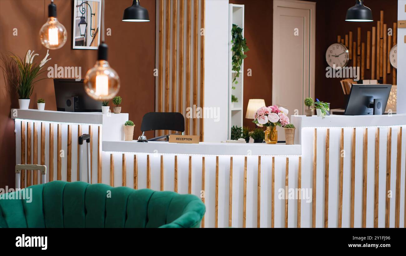 Reception dell'hotel costosa con banco ricevimento vuoto e moderno, area lounge con mobili lussuosi ed elegante banco di registrazione. Elegante rifugio di vacanza con splendido design degli interni. Foto Stock