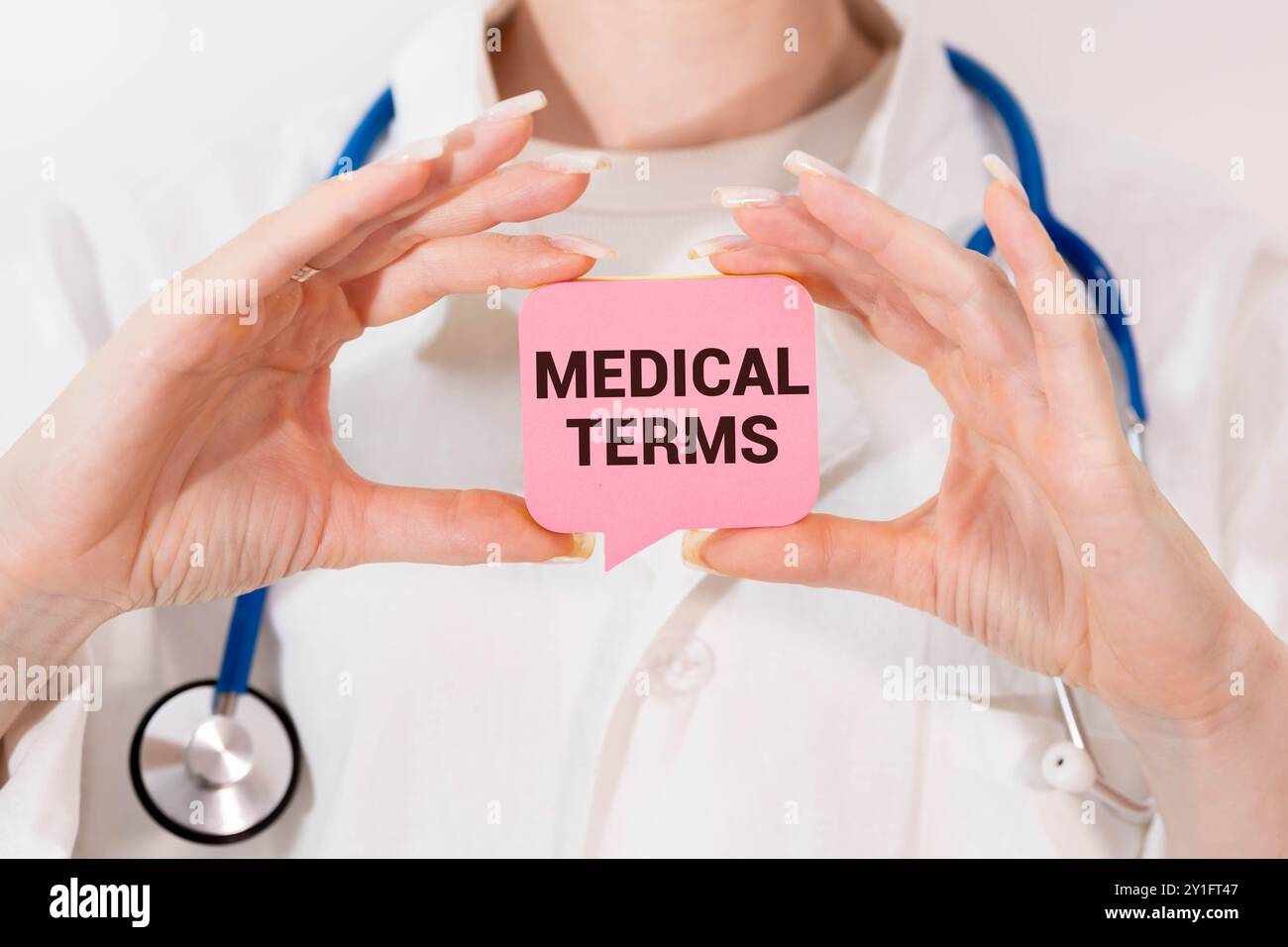 Medico in possesso di una scheda con TERMINI MEDICI di testo Foto Stock