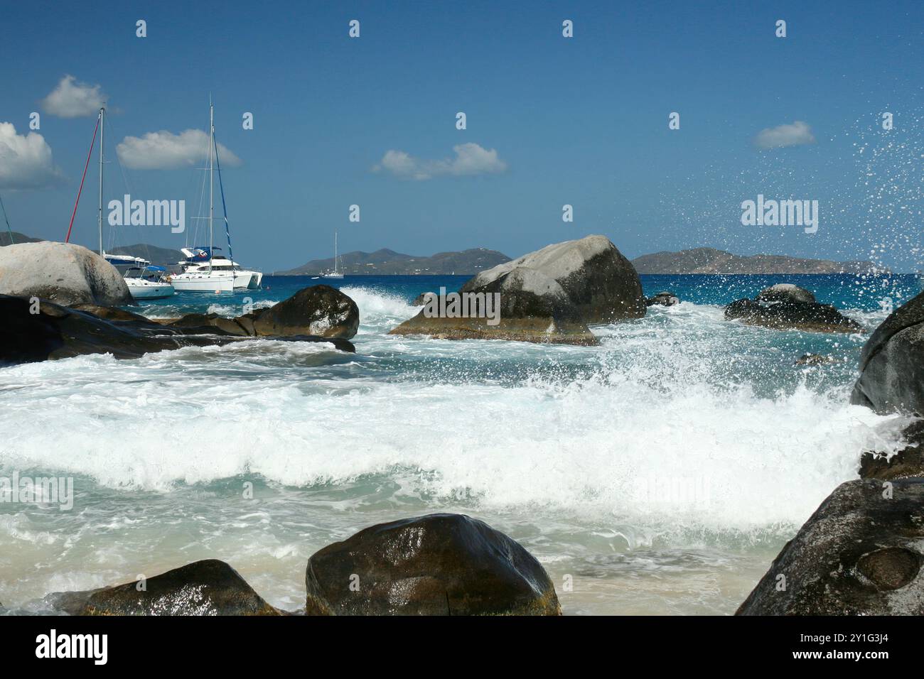 Virgin Gorda, Isole Vergini britanniche - 27 febbraio 2006: Una vista dei bellissimi massi e delle formazioni rocciose delle Terme. Le barche a vela sono ancorate Foto Stock