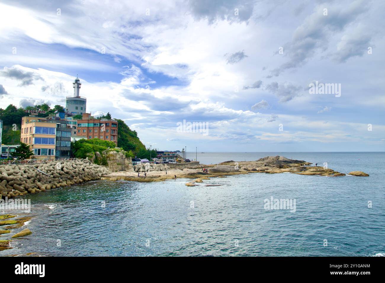 Sokcho, Corea del Sud - 28 luglio 2024: Una vista panoramica del faro di Sokcho arroccato su una collina costiera accanto a edifici moderni, che si affaccia sulla roc Foto Stock