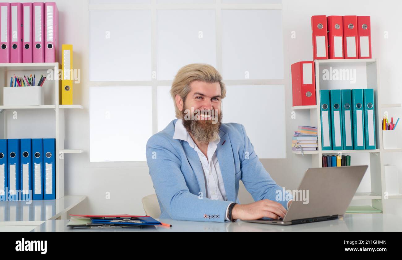 Happy Business man che lavora con pile di documenti cartacei. Ricerca di informazioni. Documenti di report e pile di documenti ottenuti sulla scrivania del computer portatile Foto Stock