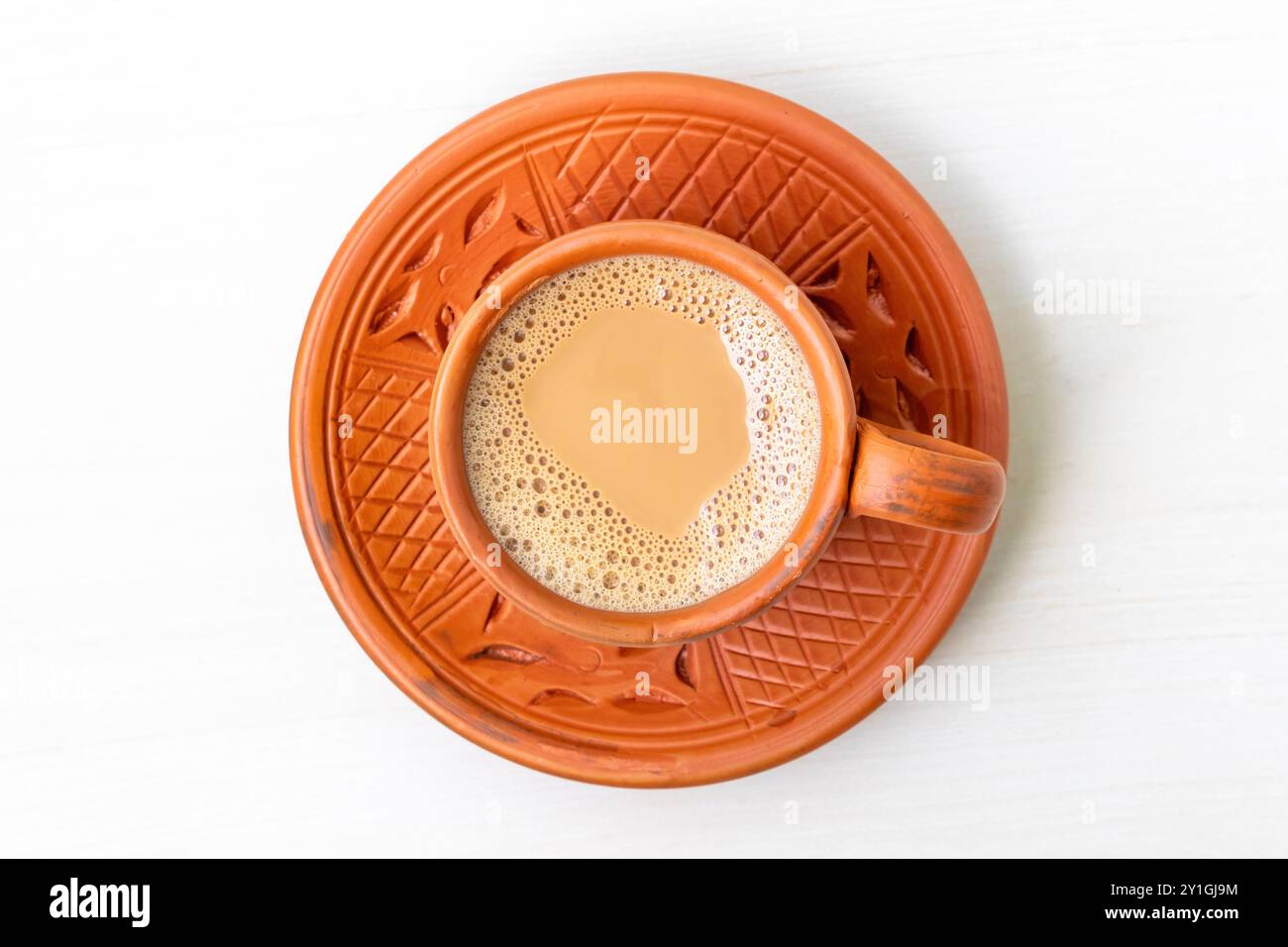 Una tazza di tè al latte caldo o Dudh Cha in una tradizionale tazza di argilla naturale. Vista dall'alto. Foto Stock