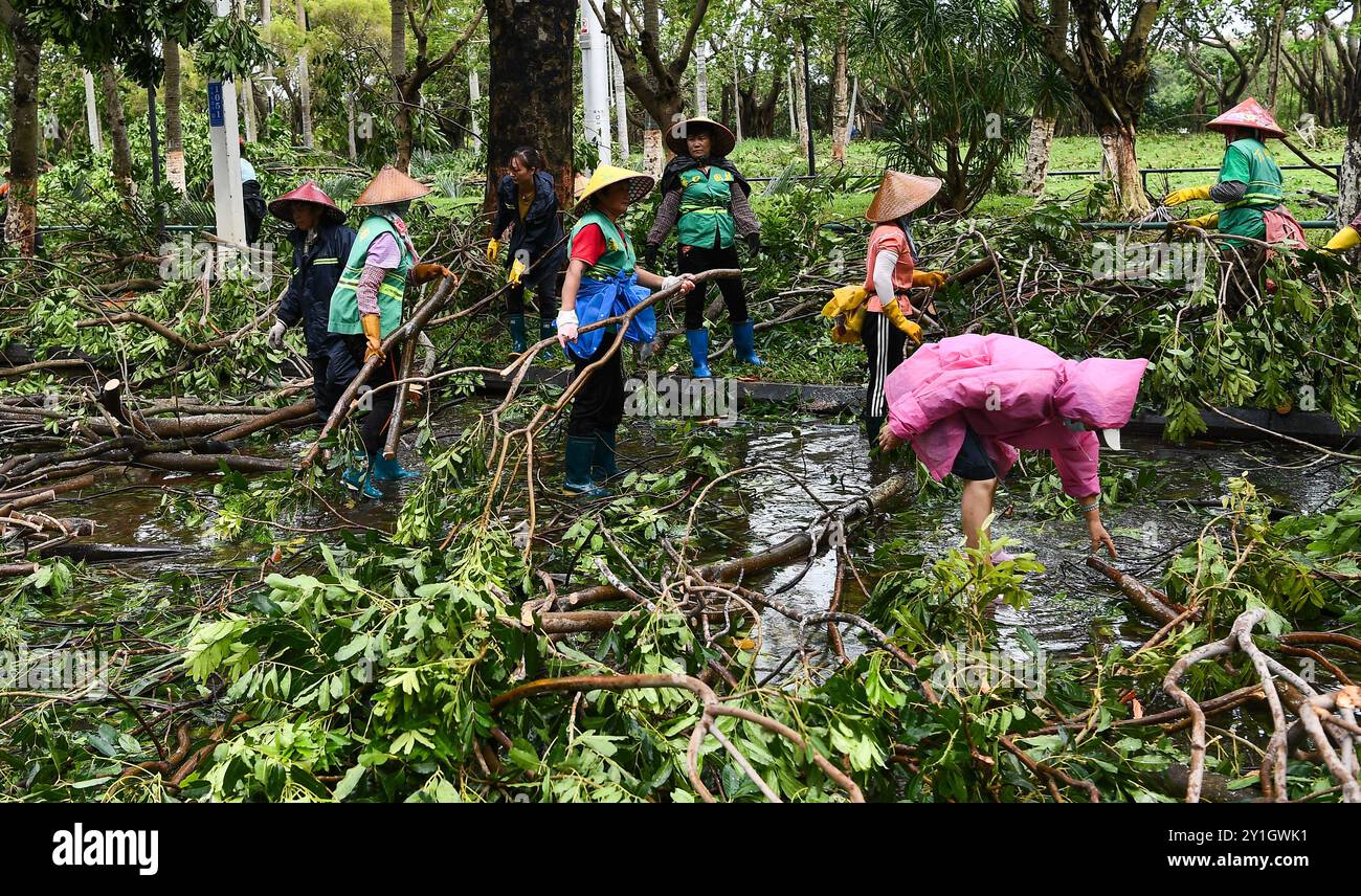 Haikou, la provincia cinese di Hainan. 7 settembre 2024. I membri del personale rimuovono i rami caduti in una strada di Haikou, nella provincia cinese meridionale di Hainan, 7 settembre 2024. Il Super Typhoon Yagi ha colpito la provincia dell'isola di Hainan, nella Cina meridionale, con forti piogge e venti gustosi, lasciando almeno due persone morte e 92 feriti, hanno detto le autorità locali sabato. Quando venti e piogge si placarono, Hainan diminuì il suo allarme tifone e avviò rapide operazioni di recupero in tutta la provincia. Crediti: Yang Guanyu/Xinhua/Alamy Live News Foto Stock