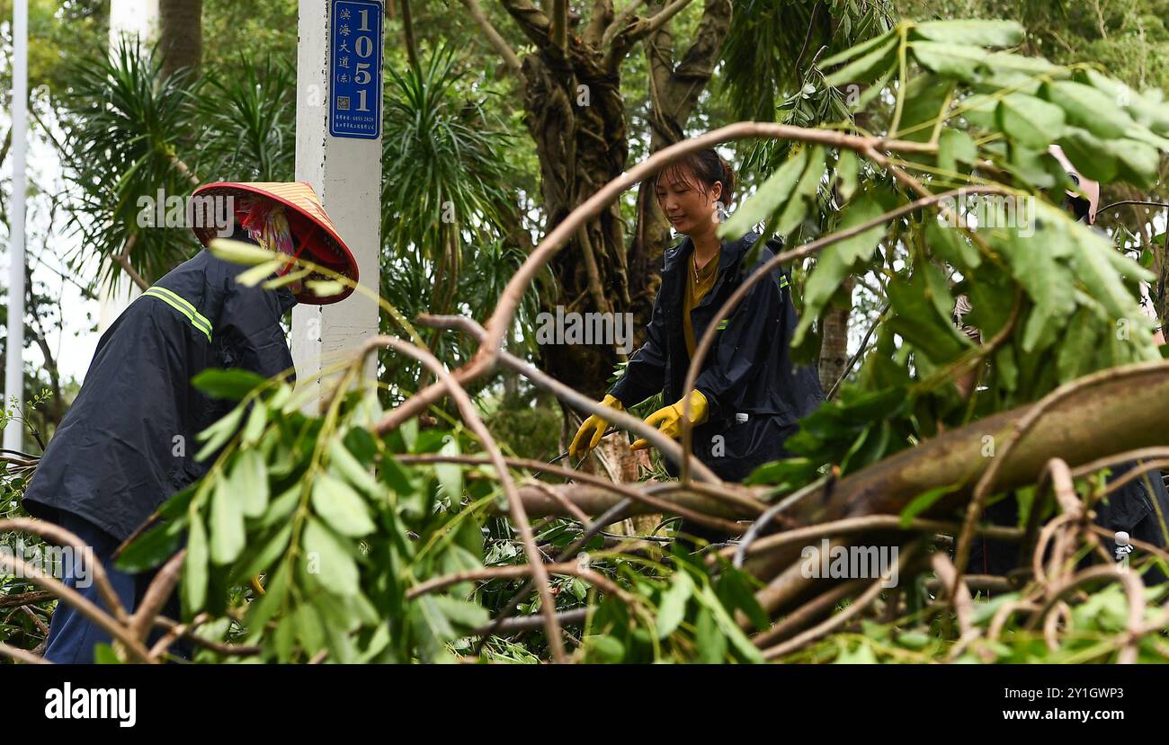 Haikou, la provincia cinese di Hainan. 7 settembre 2024. I membri del personale rimuovono i rami caduti in una strada di Haikou, nella provincia cinese meridionale di Hainan, 7 settembre 2024. Il Super Typhoon Yagi ha colpito la provincia dell'isola di Hainan, nella Cina meridionale, con forti piogge e venti gustosi, lasciando almeno due persone morte e 92 feriti, hanno detto le autorità locali sabato. Quando venti e piogge si placarono, Hainan diminuì il suo allarme tifone e avviò rapide operazioni di recupero in tutta la provincia. Crediti: Yang Guanyu/Xinhua/Alamy Live News Foto Stock