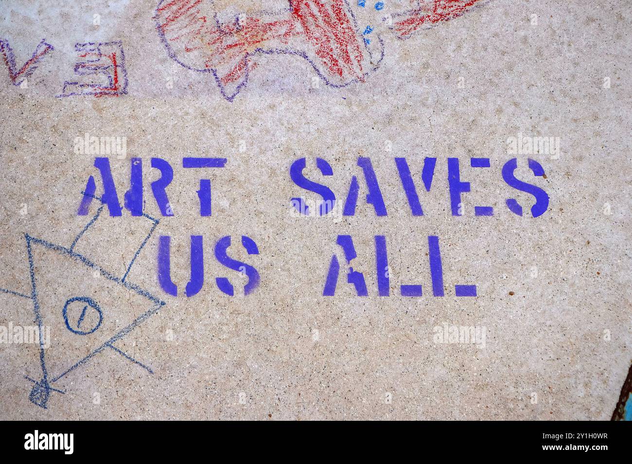 Graffiti stencil su una superficie di cemento con il testo "Art Saves Us All" accompagnato da una figura geometrica disegnata a mano. Foto Stock