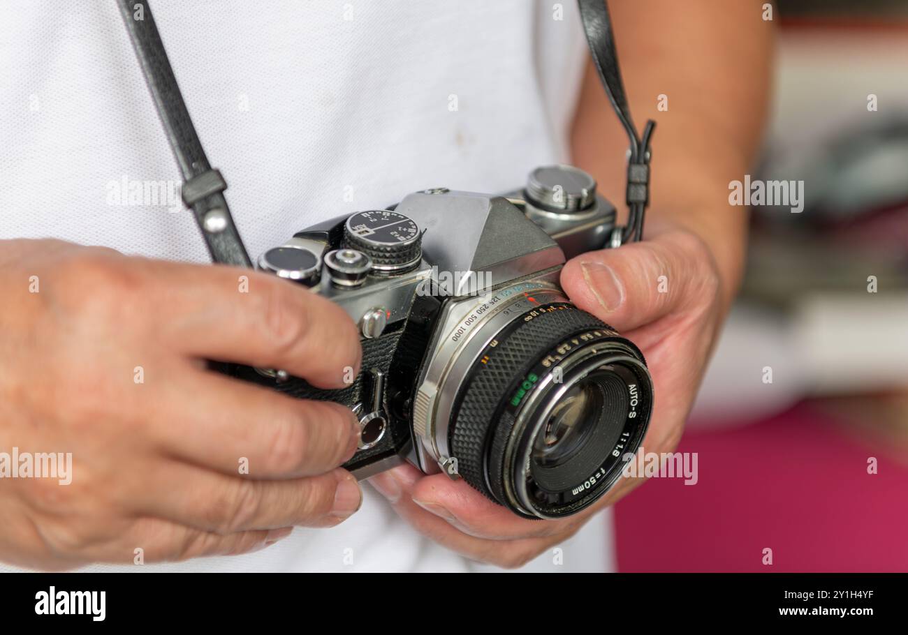 Una persona che porta con sé una fotocamera reflex vintage. Foto Stock