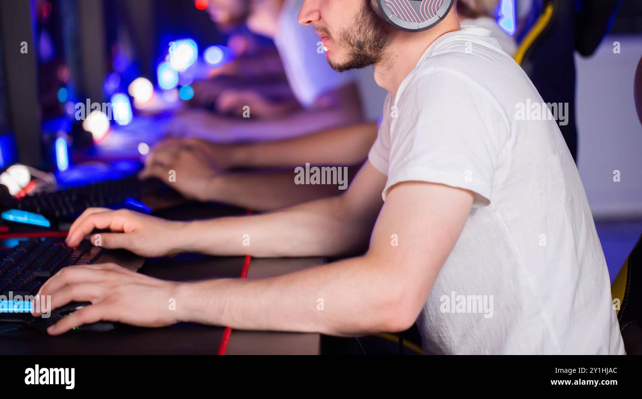 Il lettore utilizza un mouse da gioco professionale e una tastiera PC con illuminazione RGB e tappetino. Squadra informatica nel club informatico. Abilità. Torneo di eSport. I giocatori giocano a vide Foto Stock